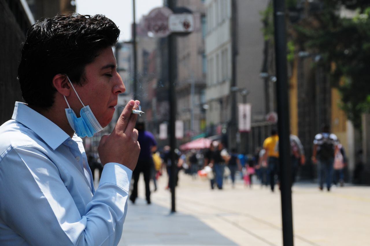 Un hombre fuma en la calle de Madero