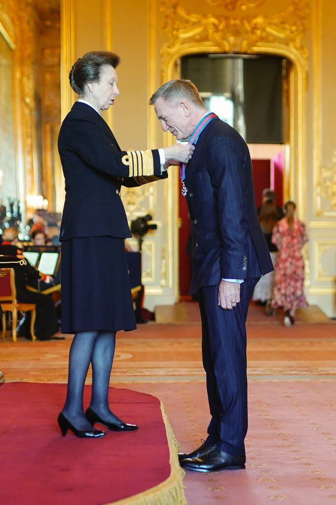 Daniel Craig recibiendo de la princesa Ana las medallas de la Orden de San Miguel y San Jorge