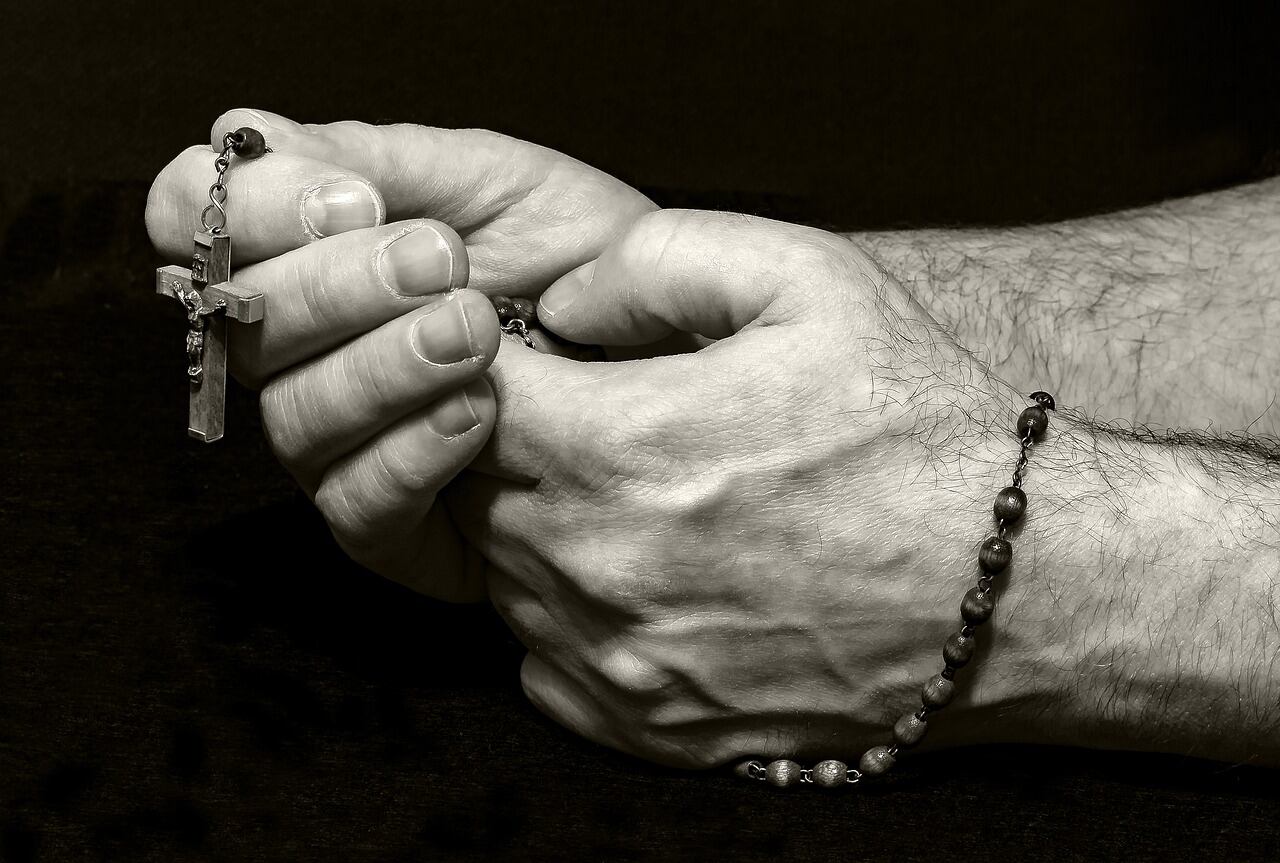 Hombre sosteniendo un rosario